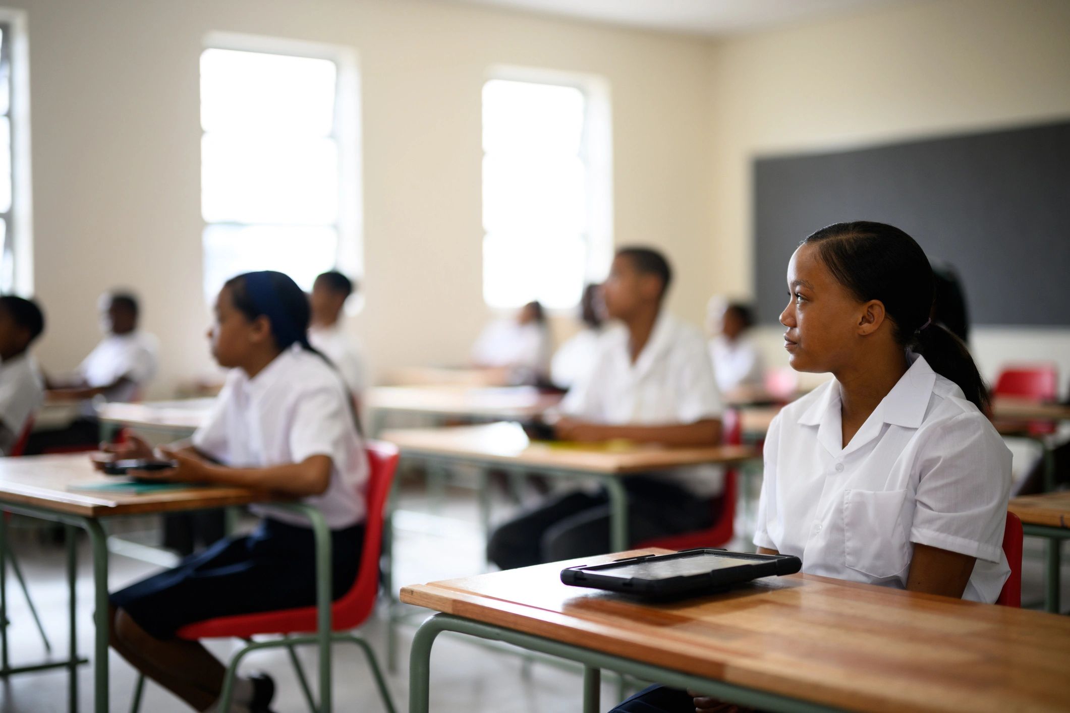 Schoolgirl sitting in class listening to teacher