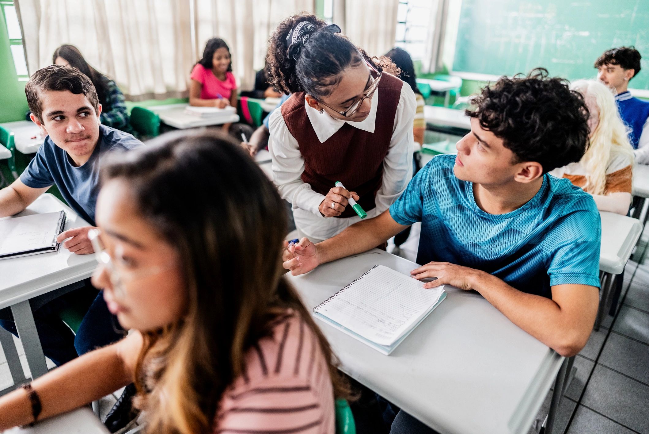 Teacher assisting a student during classroom instruction