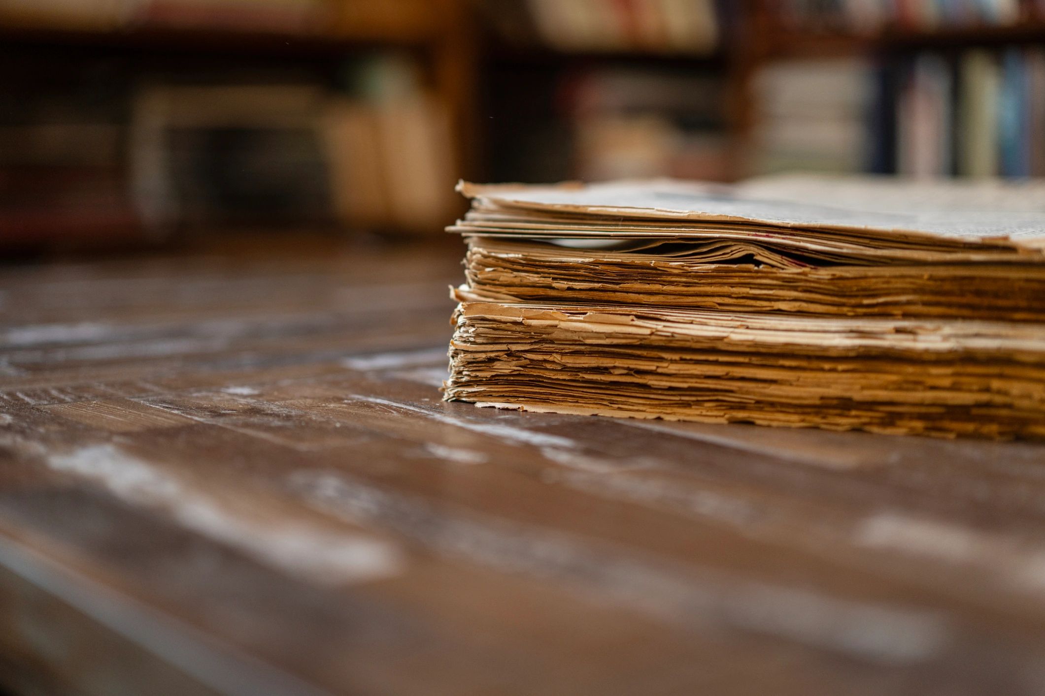 Vintage newspapers stacked on a wooden table