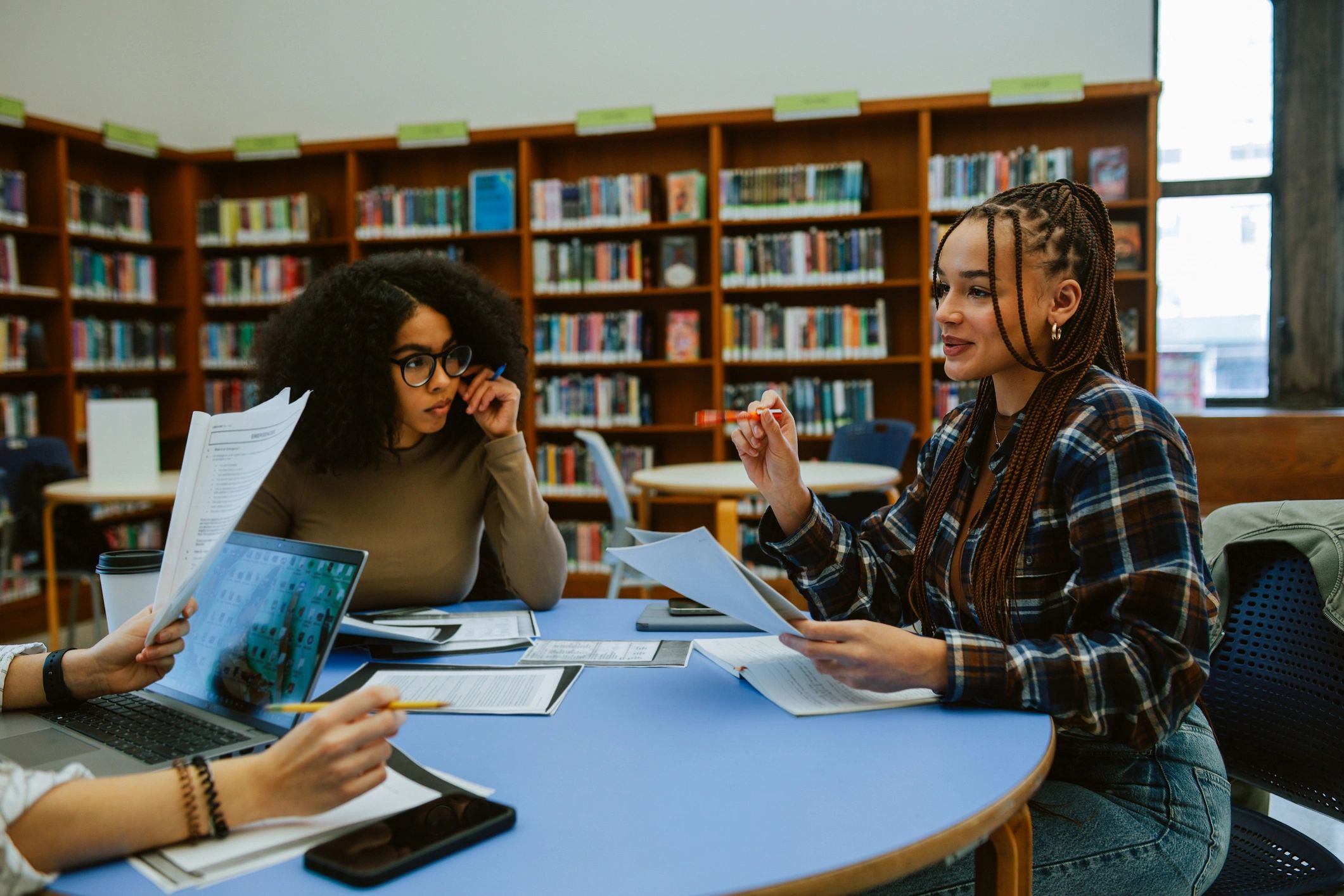 Academic partners gathered around a table in a library