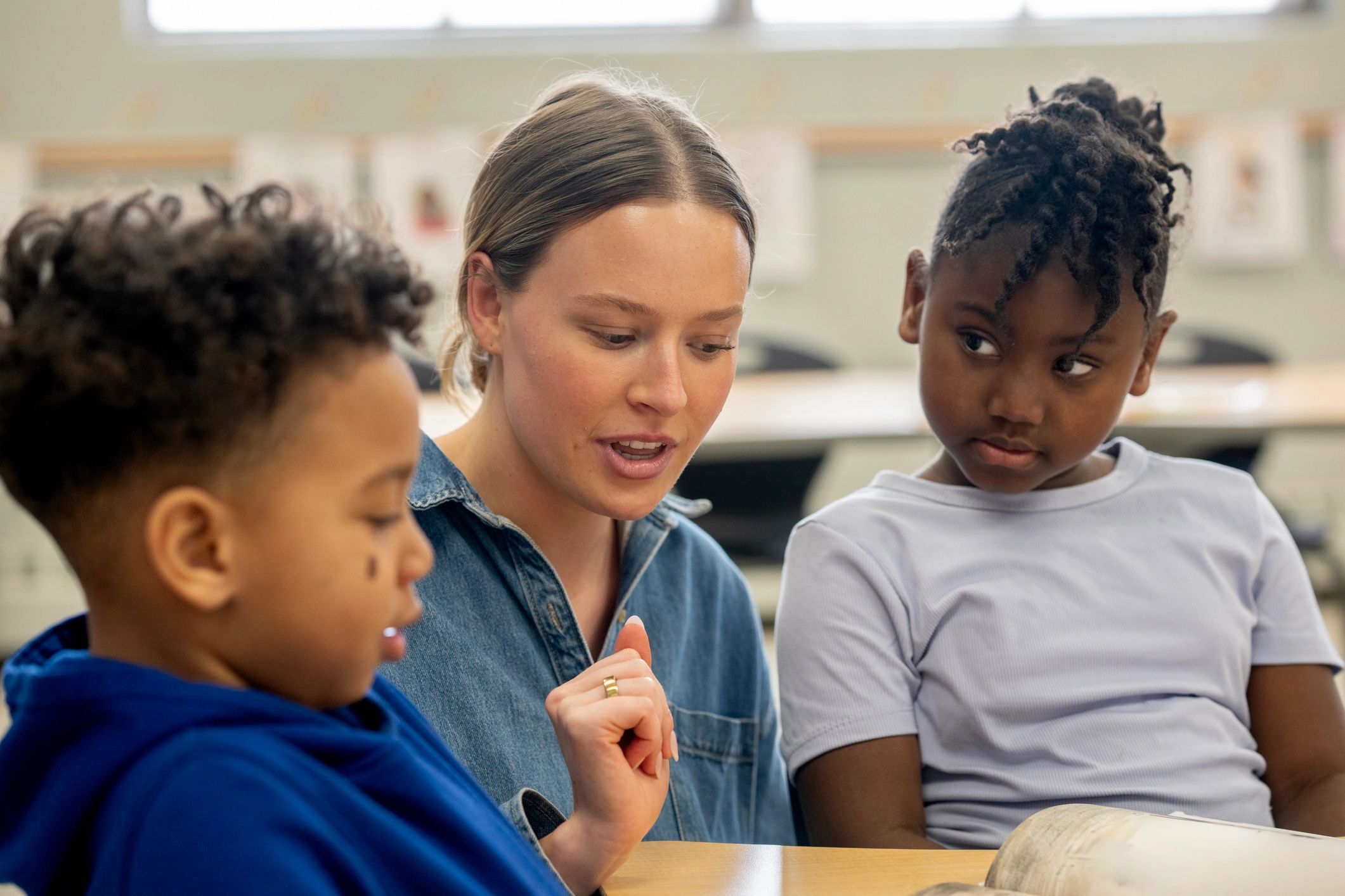 Teacher tutoring students at classroom table