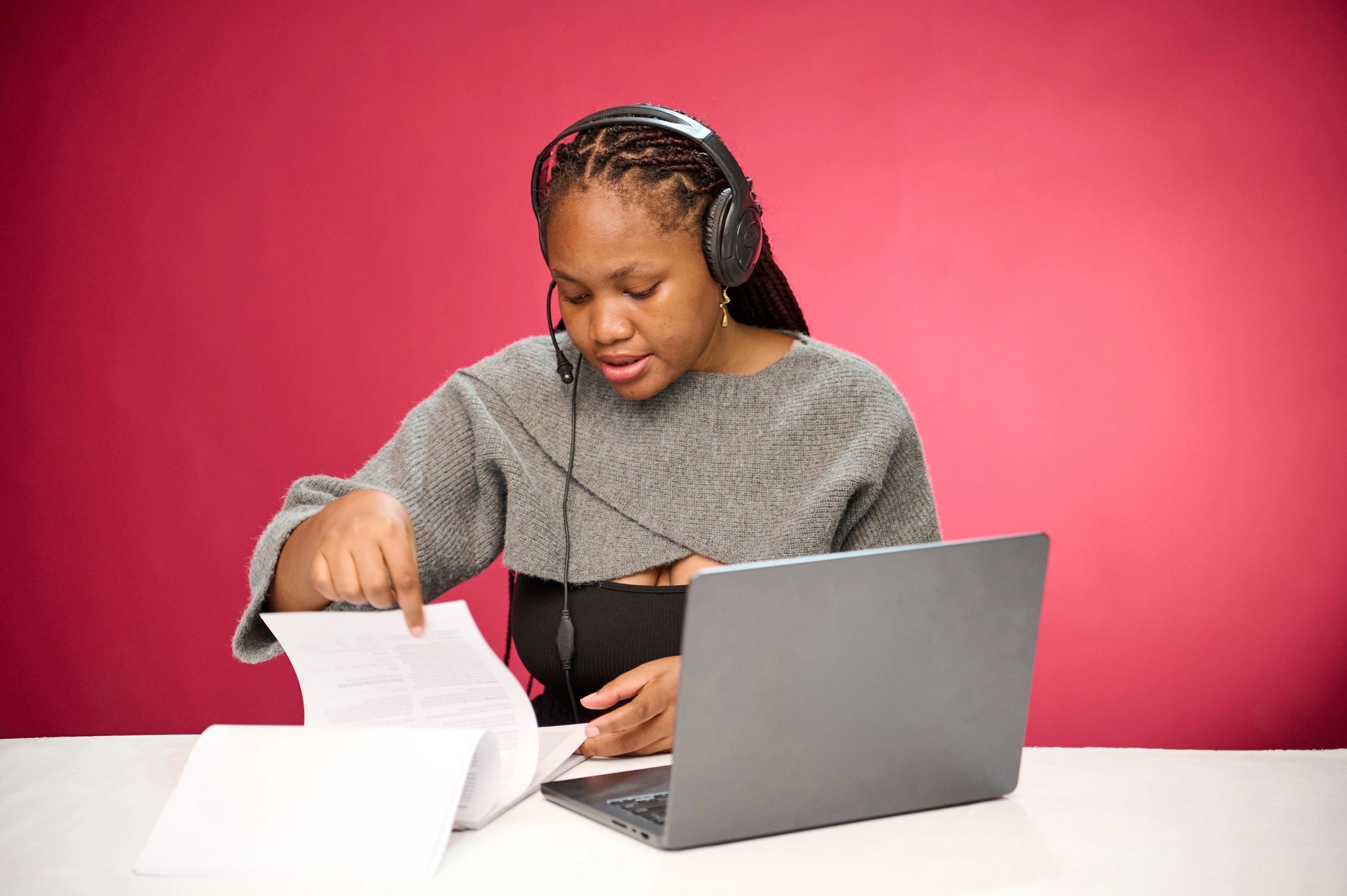 Researcher reviewing documents and working on a laptop